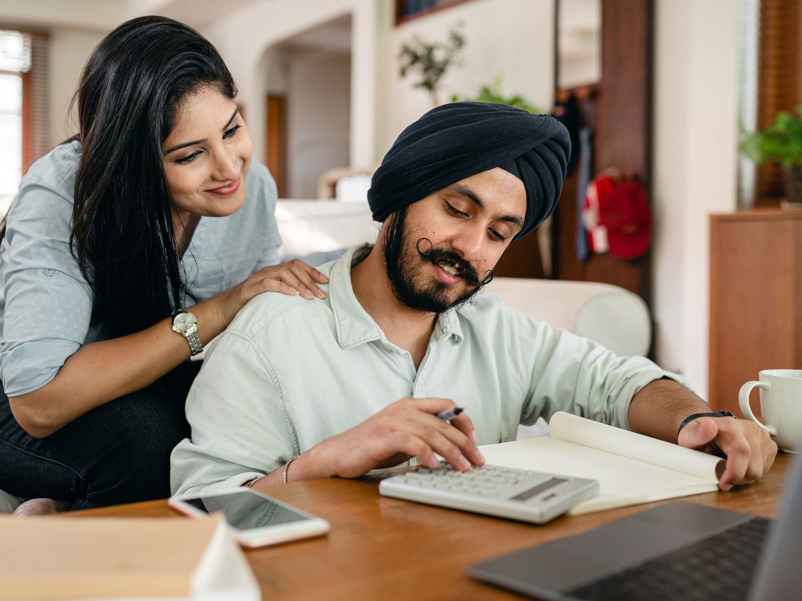 Coppia che organizza le proprie finanze domestiche con una calcolatrice